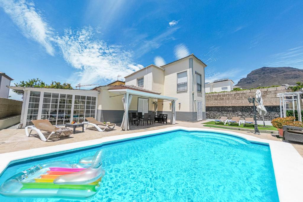 una piscina frente a una casa en Cozy villa in Madroñal de Fañabe with large private pool, en Adeje