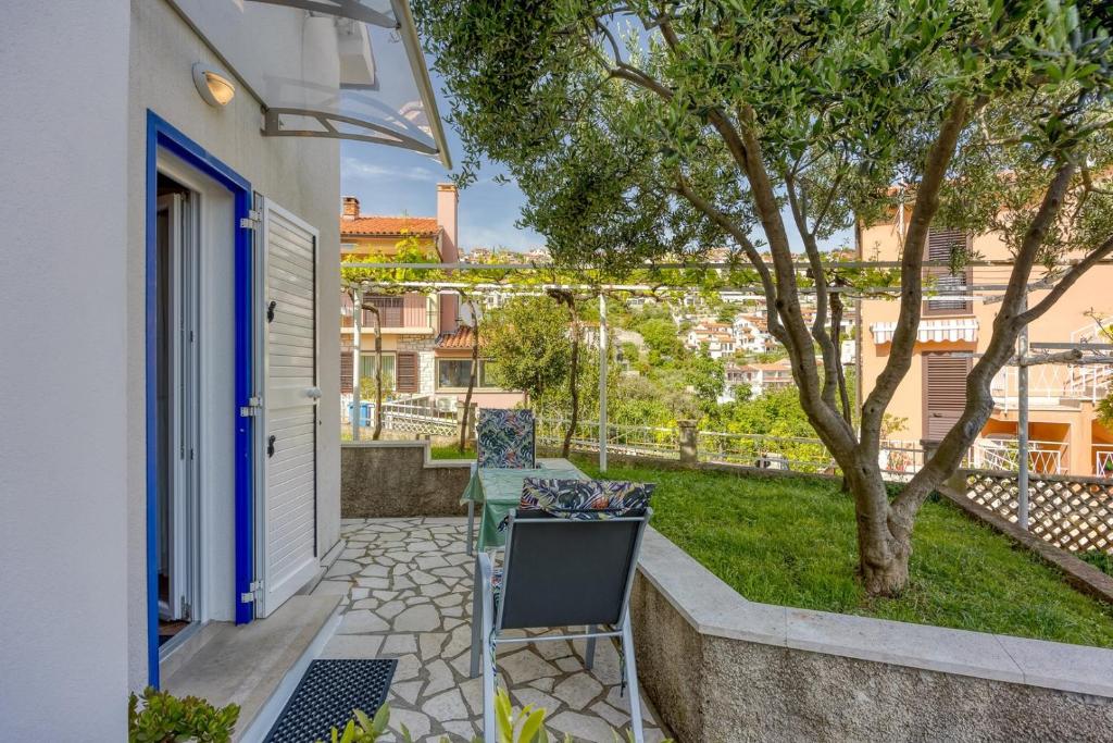 a patio with a chair and a tree at Apartments Marija 1000 in Rabac
