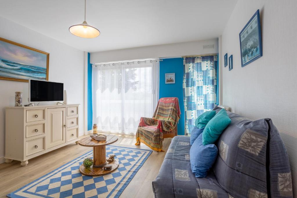 een woonkamer met een bank en een tv bij Appartement Le Croas Men in Douarnenez