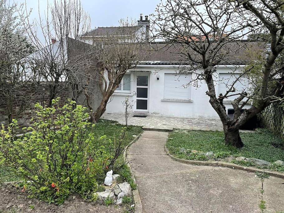 a white house with a tree and a driveway at Belle maison proche mer Sangatte Blériot-plage in Sangatte