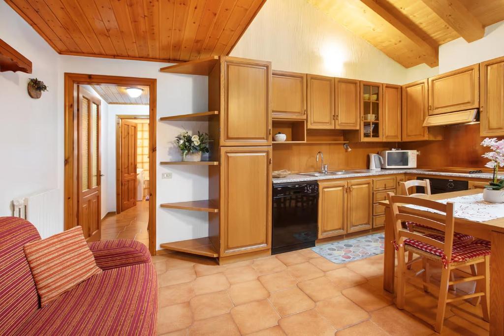 a large kitchen with wooden cabinets and a table at Baita Florin in Livigno
