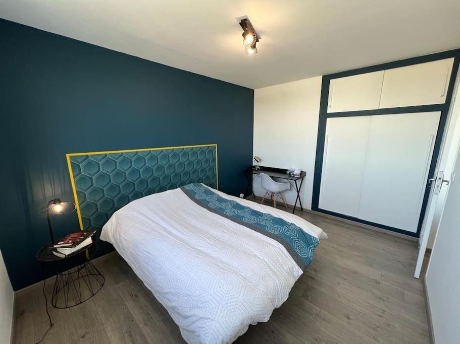 une chambre avec un lit et une grande fenêtre dans l'établissement Une chambre privée bleu dans un appartement partagé, à Orléans