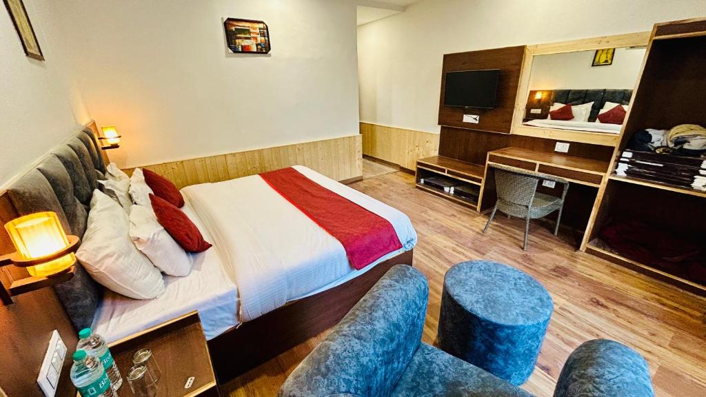 Habitación de hotel con cama y escritorio en Hotel Ocean Mountain View, en Manali