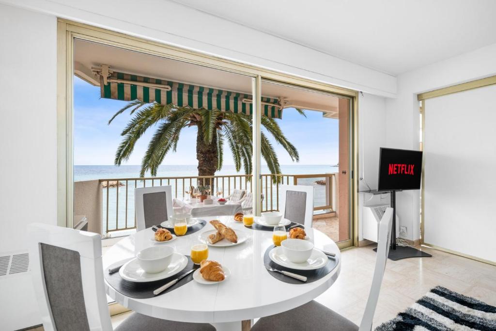 une salle à manger blanche avec une table et une vue sur l'océan dans l'établissement Le COQ Ligures - Garage - Air conditioning - WiFi, à Roquebrune-Cap-Martin
