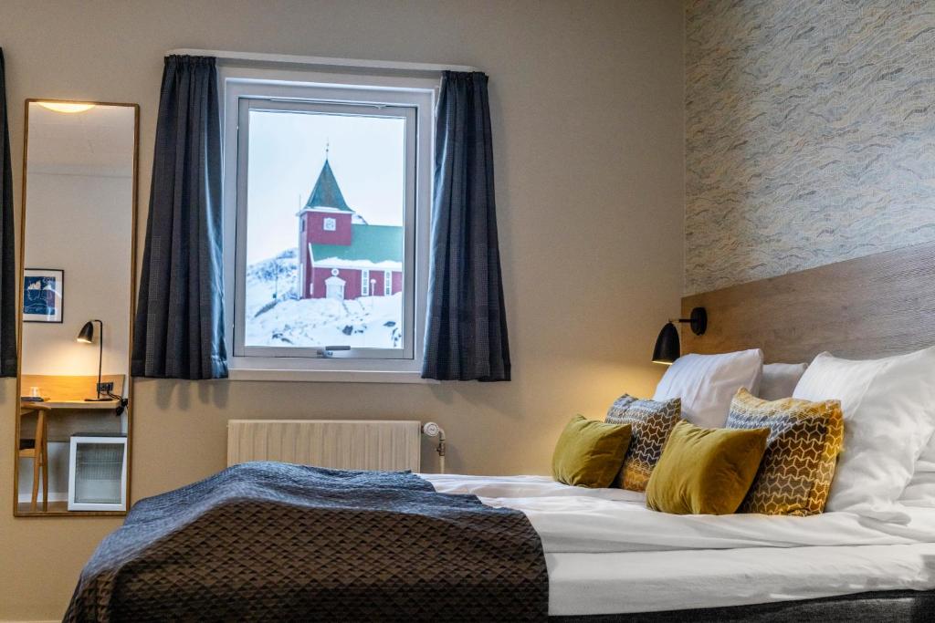 Un dormitorio con una cama grande y una ventana en HOTEL SØMA Sisimiut en Sisimiut