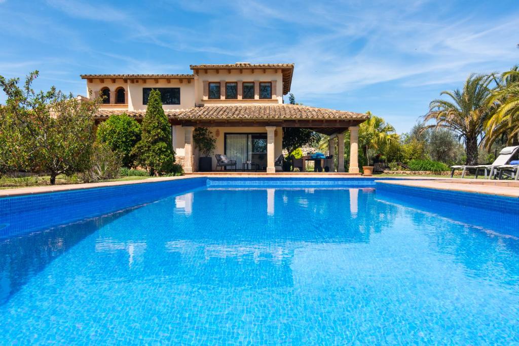 une villa avec une piscine en face d'une maison dans l'établissement Moliner PREMIUM VILLA, à Pollença