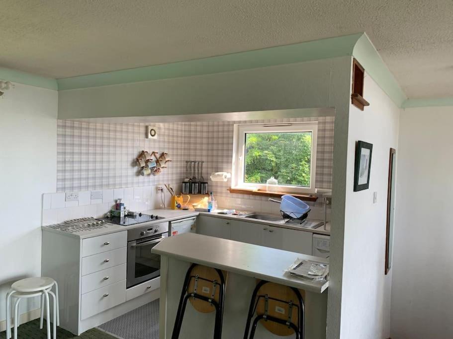a kitchen with a counter and a window in it at Alba, Beach Front Close to Restaurant in Lamlash