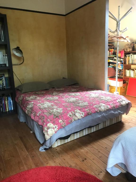 een slaapkamer met een bed met een rood dekbed bij Grande chambre 3 couchages in Parmain