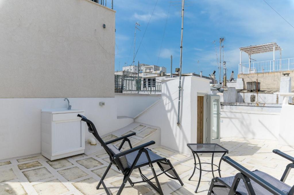 Un balcón con sillas y un lavabo en el techo. en Terrazza GiuMaSe by Wonderful Italy, en Ostuni