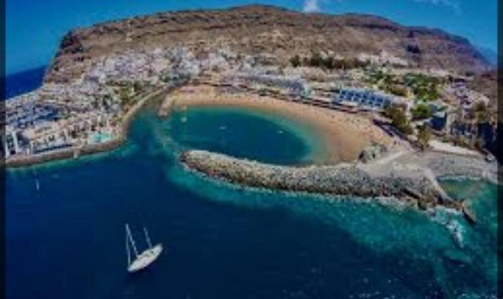 una isla con un barco en un cuerpo de agua en Puerto de Mogan Sonneland, en Puerto de Mogán
