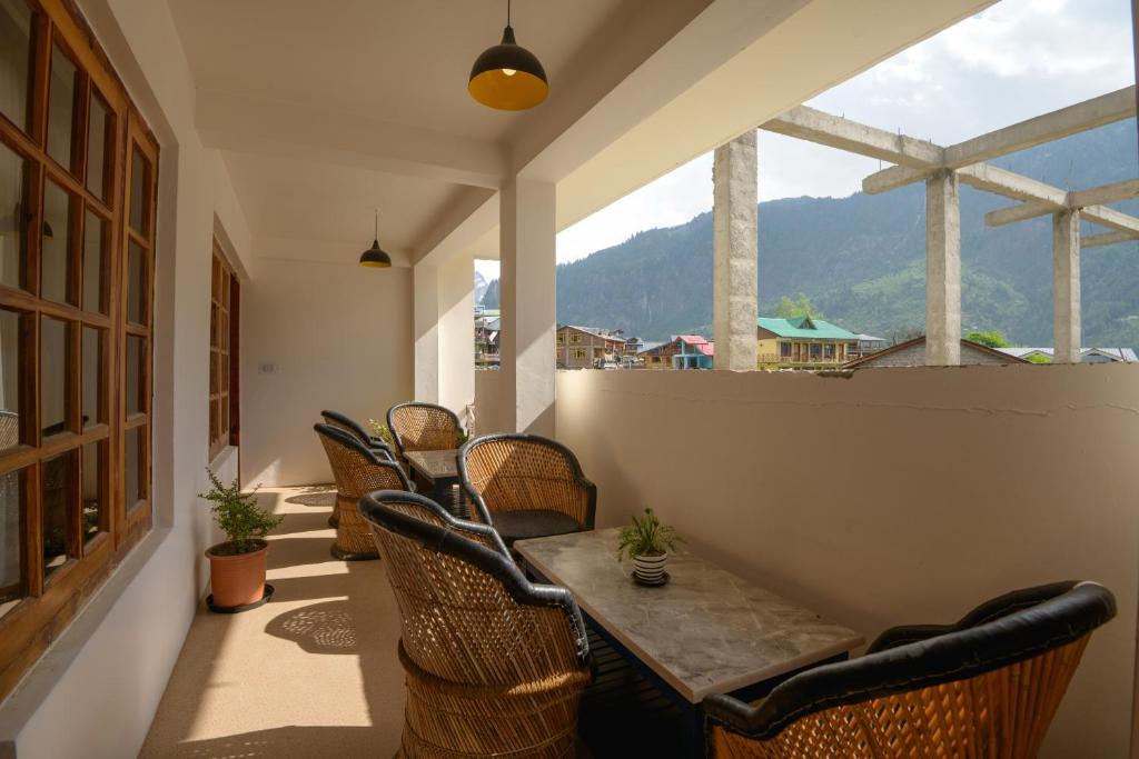 a table and chairs on a balcony with a view at Drifters Inn - The Hidden Tribe in Manāli