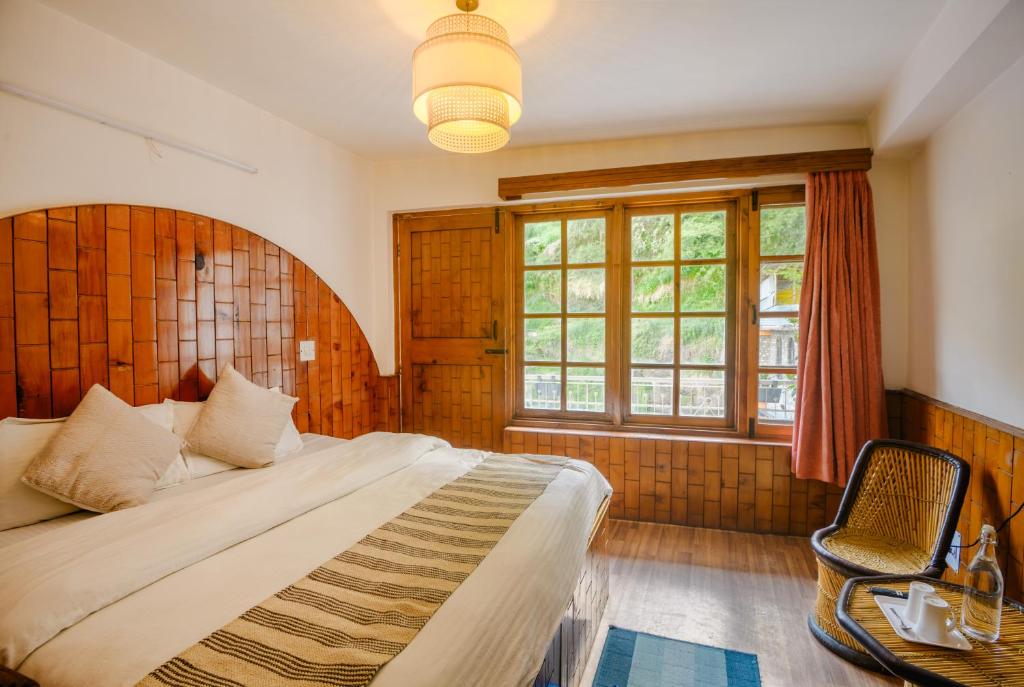 a bedroom with a large bed and a window at Drifters Inn - The Hidden Tribe in Manāli