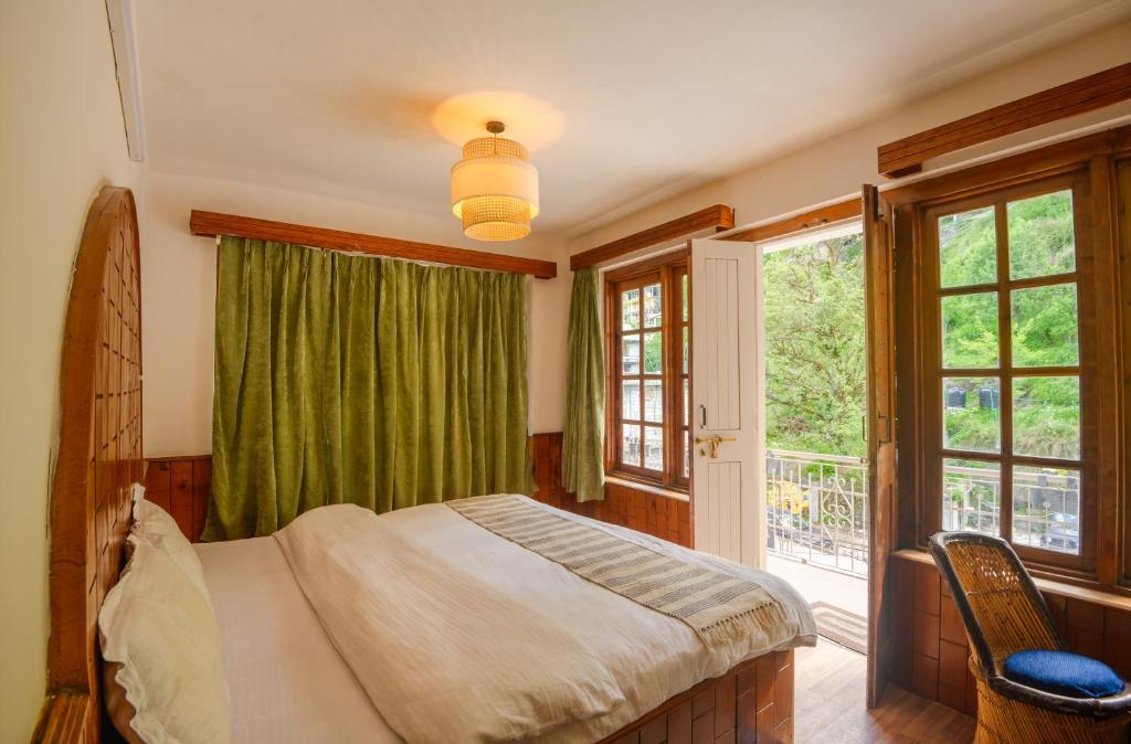 a bedroom with a bed and a large window at Drifters Inn - The Hidden Tribe in Manāli