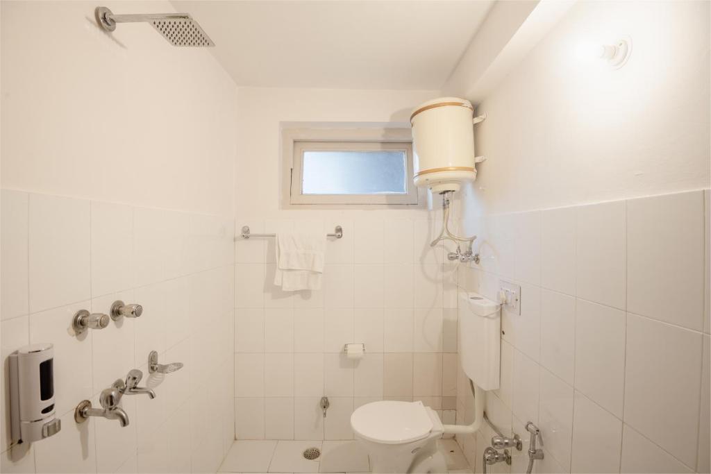 a white bathroom with a toilet and a shower at Drifters Inn - The Hidden Tribe in Manāli