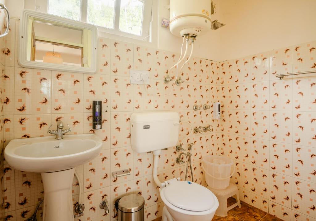 a bathroom with a toilet and a sink at Drifters Inn - The Hidden Tribe in Manāli