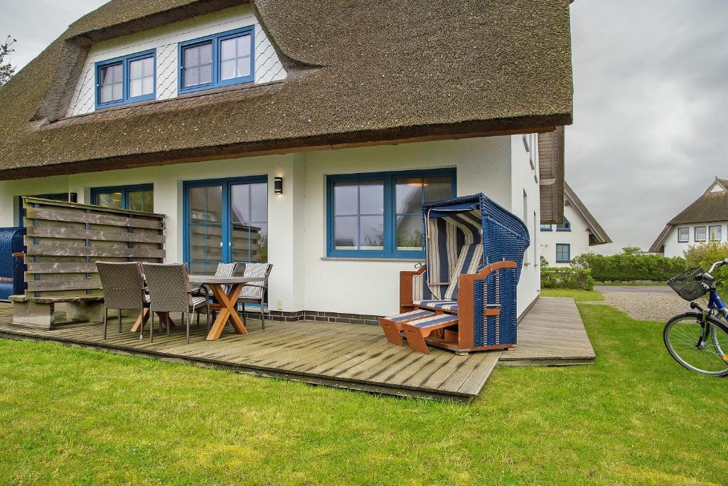 a house with a deck with a table and chairs at Ferienhaus Seestern in Dranske