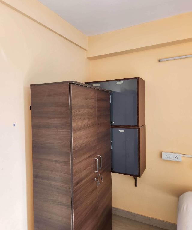 drewniane drzwi w rogu pokoju w obiekcie OYO R Guest House Near Netaji Subhash Chandra Bose International Airport w mieście Salua
