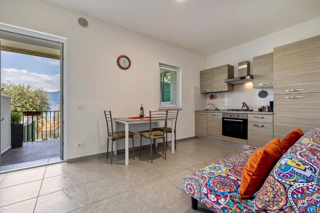 uma sala de estar com um sofá e uma cozinha com uma mesa em Casa Maria Lake View em Brenzone sul Garda