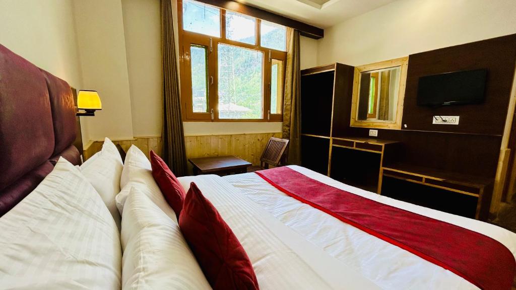 - une chambre avec un lit, une fenêtre et une télévision dans l'établissement Hotel Ocean Hill, à Manali