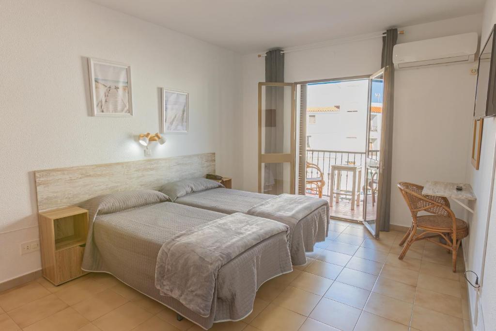 a bedroom with a bed and a balcony at Hotel Tres Jotas Conil in Conil de la Frontera