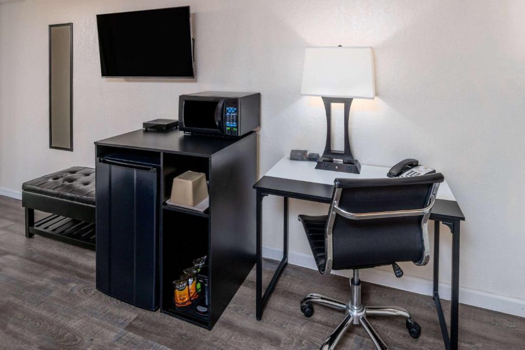 Cette chambre comprend un bureau avec un ordinateur et une chaise. dans l'établissement Super 8 by Wyndham Cheyenne WY, à Cheyenne