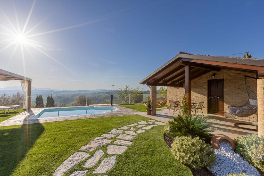 un patio trasero con piscina y una casa en Casa Grazia, en San Giorgio di Pesaro