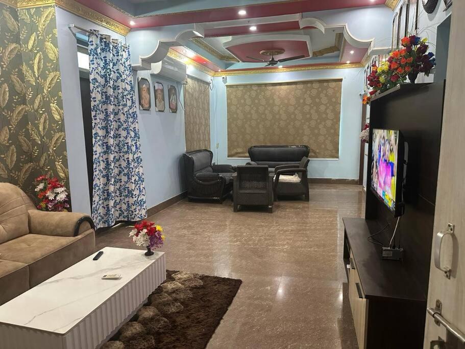 Il comprend un salon doté d'un canapé et d'une télévision à écran plat. dans l'établissement Stunning 4-Bedroom Family Haven, à Patna