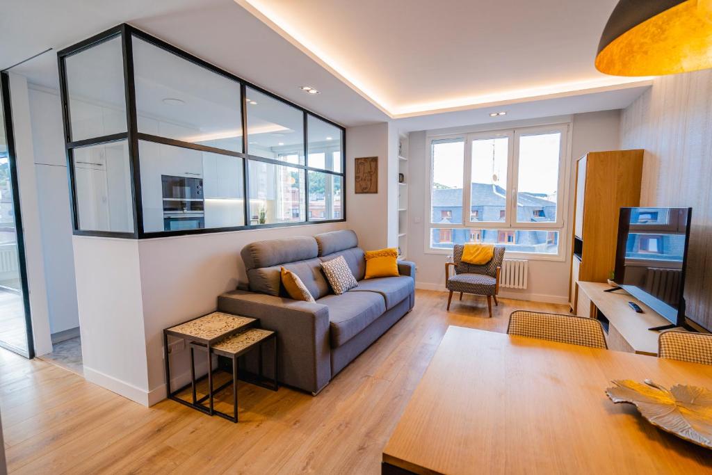 a living room with a couch and a tv at Cid Campeador I - Apartamentos Burgos Deluxe in Burgos