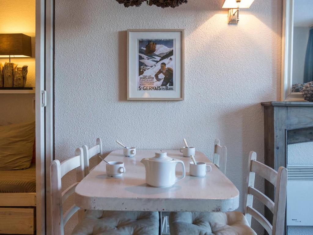 ein weißer Tisch mit Stühlen und ein Tisch mit Tassen darauf in der Unterkunft Studio Les Arcs 1800, 1 pièce, 4 personnes - FR-1-346-464 in Arc 1800