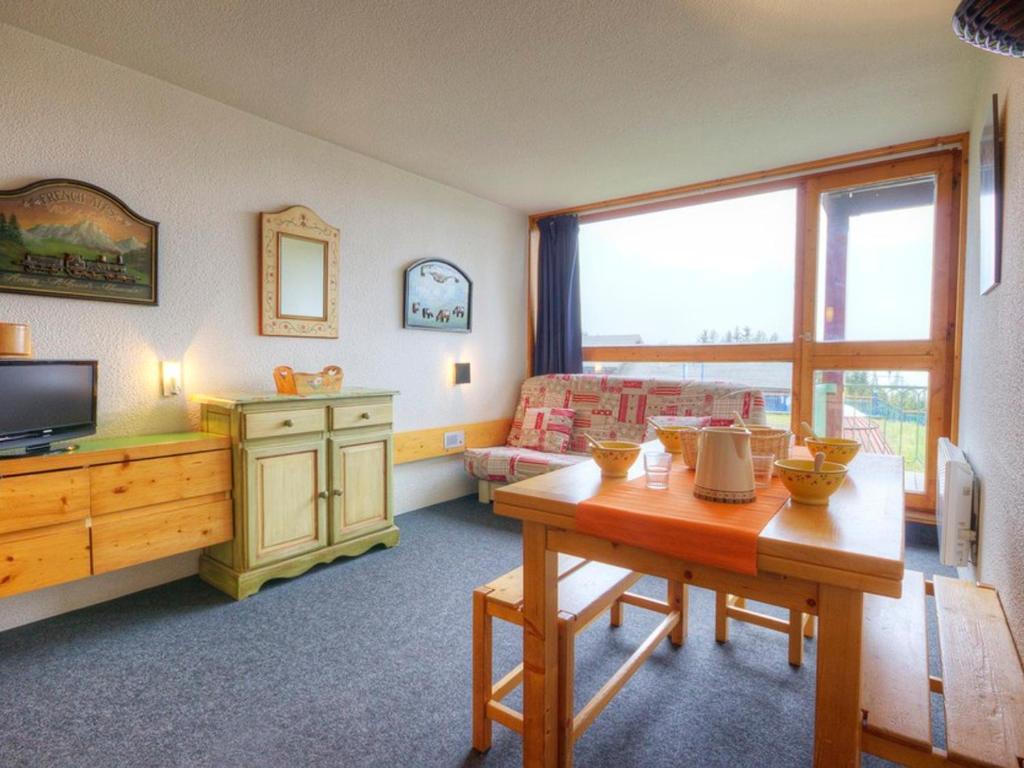 ein Wohnzimmer mit einem Tisch und einem TV in der Unterkunft Appartement Les Arcs 1800, 2 pièces, 5 personnes - FR-1-346-490 in Arc 1800