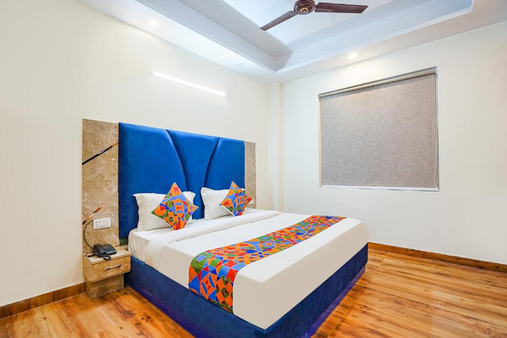 um quarto com uma cama grande e uma cabeceira azul em FabHotel The Luxe Inn em Nova Deli
