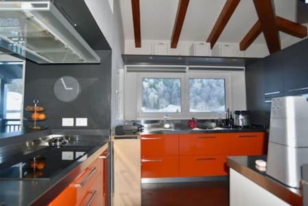 una cocina con encimeras y ventanas de color naranja y negro en Tutti insieme a Caldonazzo, en Caldonazzo