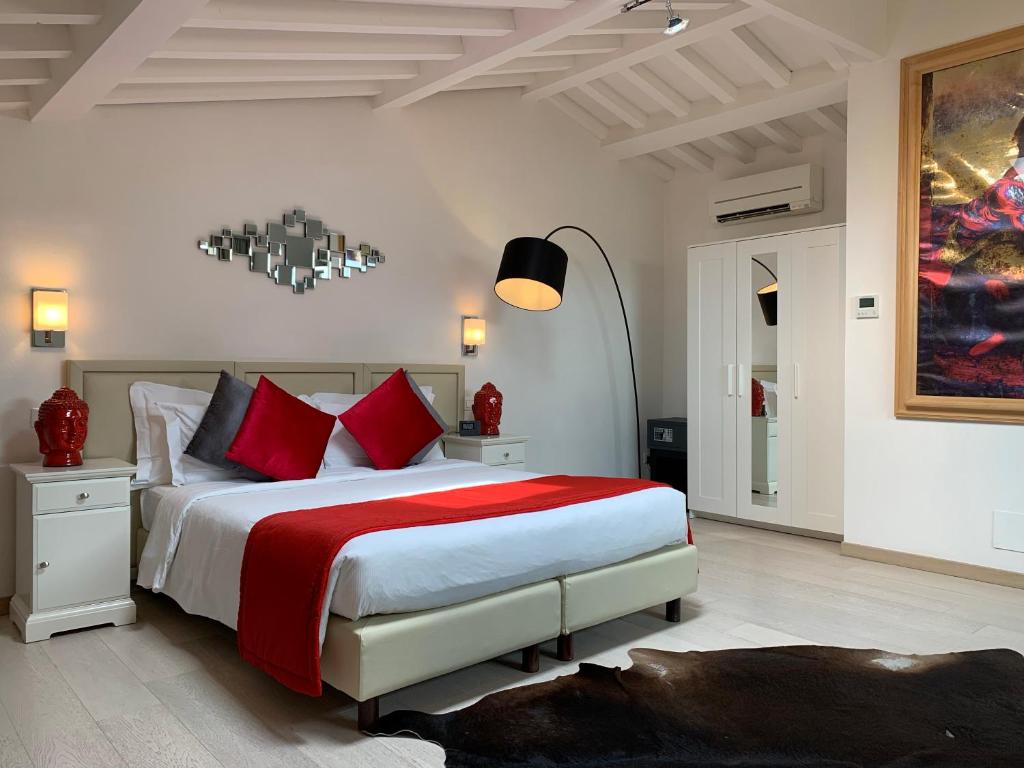 a bedroom with a large bed with red pillows at Florence Art Apartments in Florence