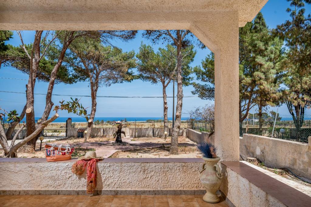 Cette chambre offre une vue sur l'océan et les arbres. dans l'établissement Villa Naumachos, à San Vito Lo Capo