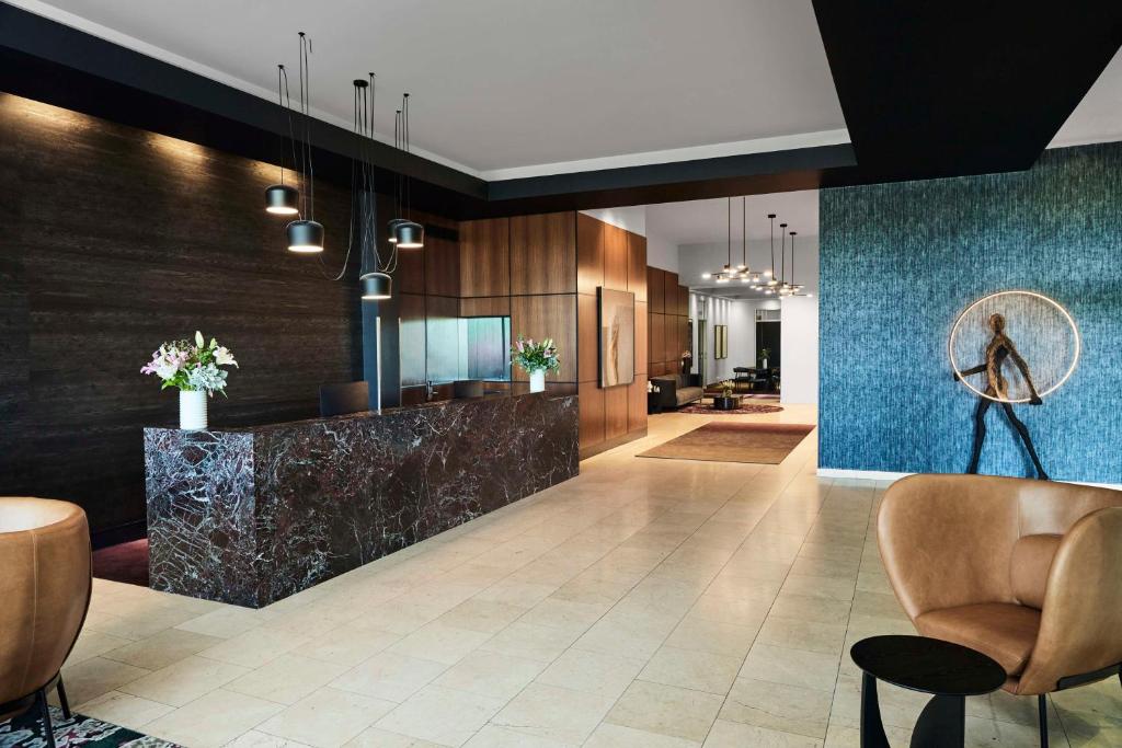 un vestíbulo con barra y sillas y un vestíbulo con paredes azules en Adina Apartment Hotel Melbourne Flinders Street, en Melbourne