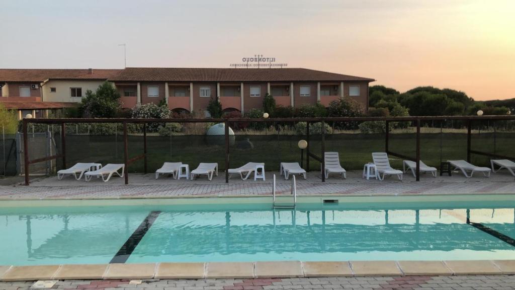 皮淋奇皮納阿馬烈的住宿－湯布洛公寓式酒店，一个带椅子的游泳池和一个背景建筑