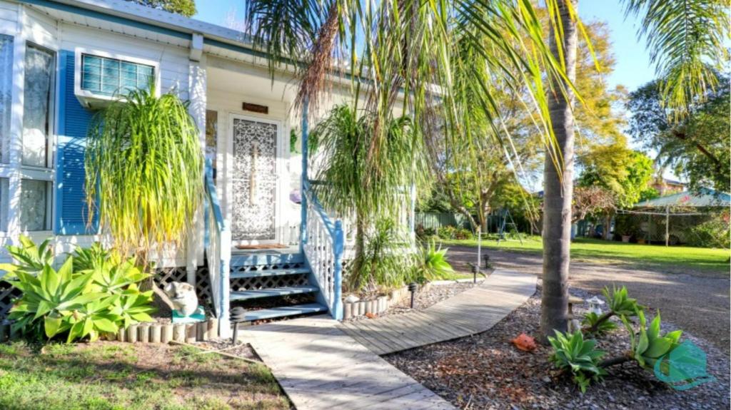 ein blaues Haus mit Palmen davor in der Unterkunft Bromyard Cottage in Swansea