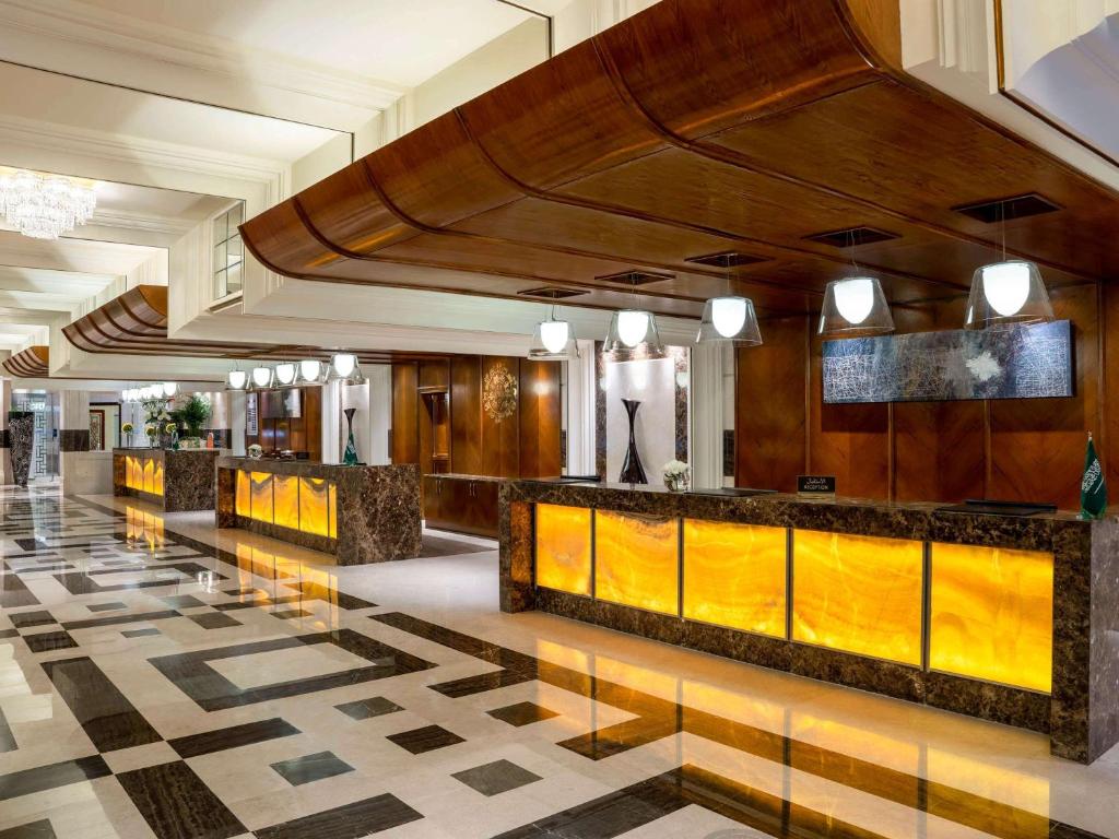 a lobby of a hotel with a reception counter at Swissotel Al Maqam Makkah in Mecca