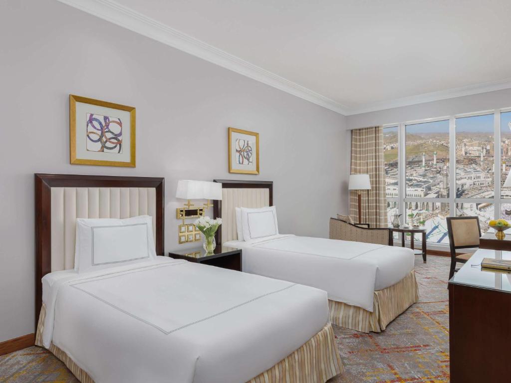 a hotel room with two beds and a window at Swissotel Al Maqam Makkah in Mecca