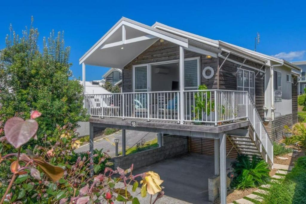 a house with a porch and a deck at Haven at Caves in Caves Beach