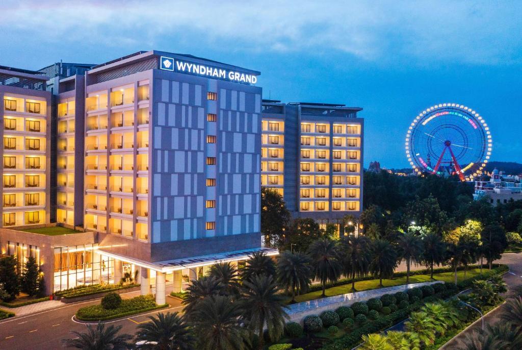 um edifício de hotel com uma roda gigante ao fundo em Wyndham Grand Phu Quoc em Phu Quoc