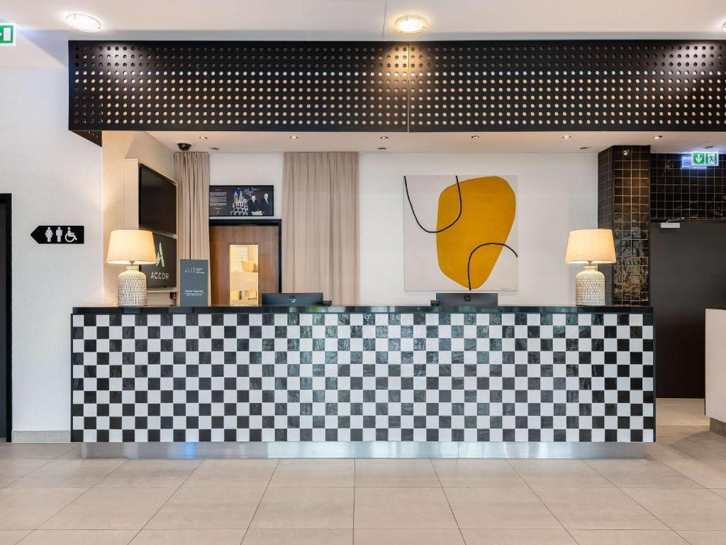 un vestíbulo con un mostrador a cuadros con una foto de un plátano en ibis Styles Warszawa Airport en Varsovia