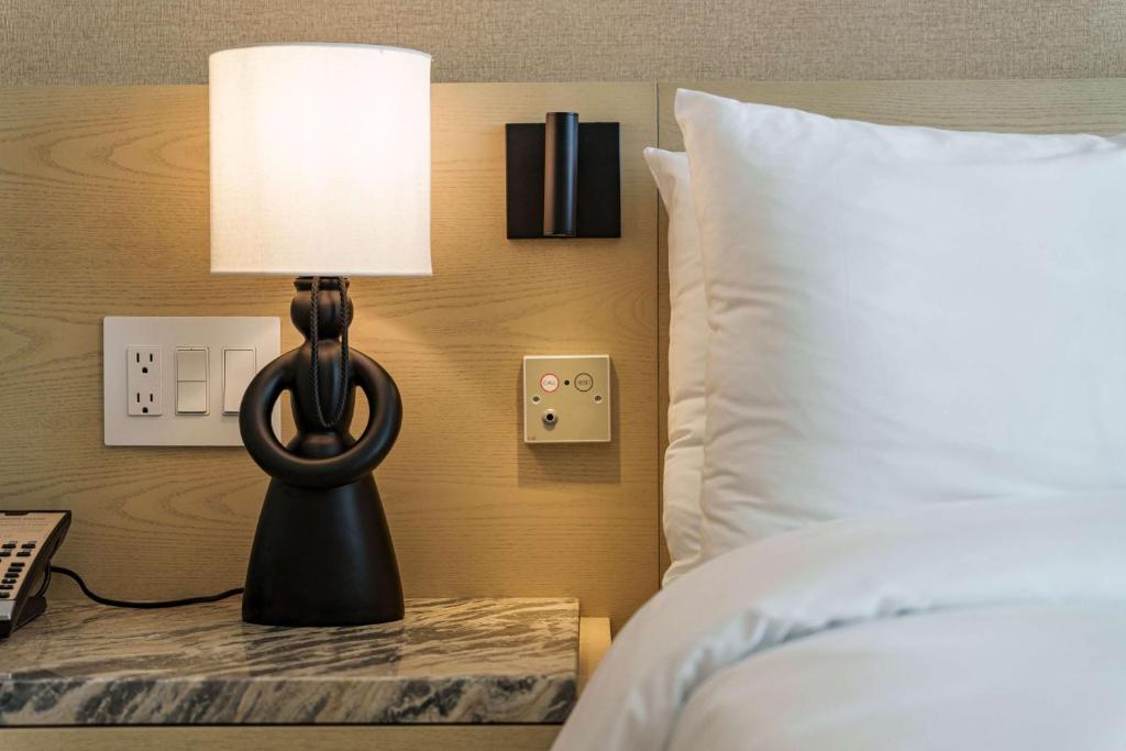a lamp on a table next to a bed at Wyndham Grand Barbados Sam Lords Castle All Inclusive Resort in Saint Philip