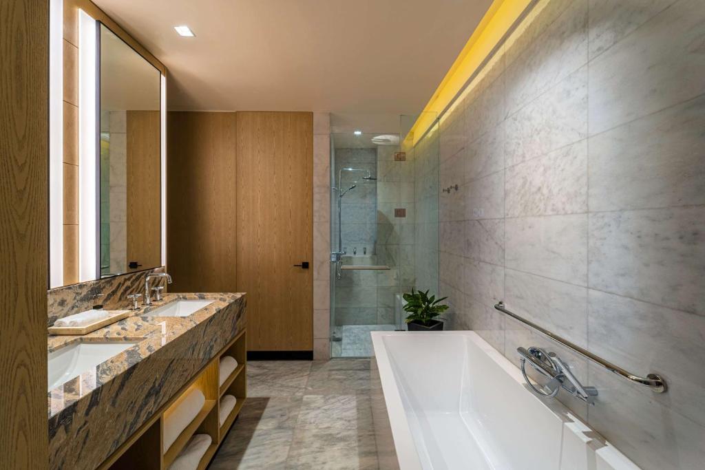 a bathroom with two sinks and a tub and a shower at Wyndham Grand Barbados Sam Lords Castle All Inclusive Resort in Saint Philip