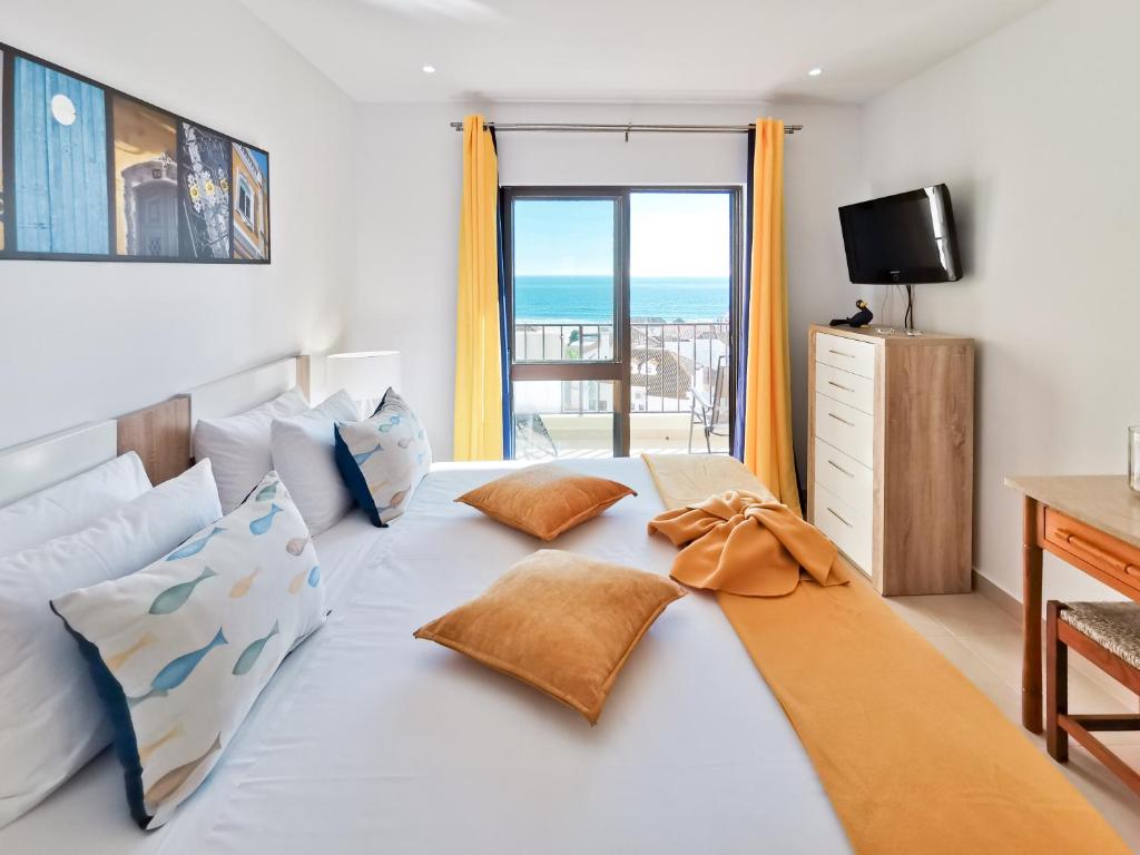 - une chambre avec un lit et une vue sur l'océan dans l'établissement Apartment Praia Rocha Vista Mar Sand, à Portimão