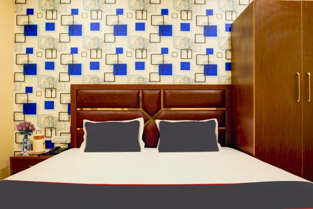 - une chambre avec un lit aux carrés bleus sur le mur dans l'établissement Collection O Blue Diamond, à Allahābād