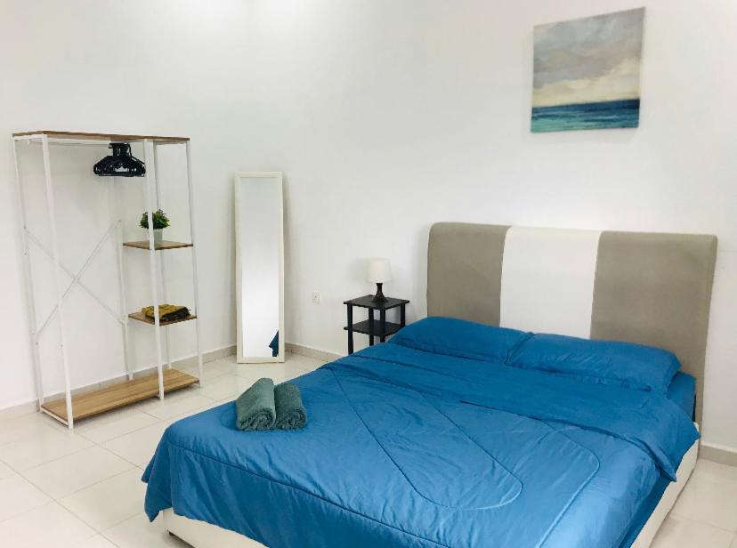 a bedroom with a blue bed in a white room at De Lumpur Guest House in Kuantan