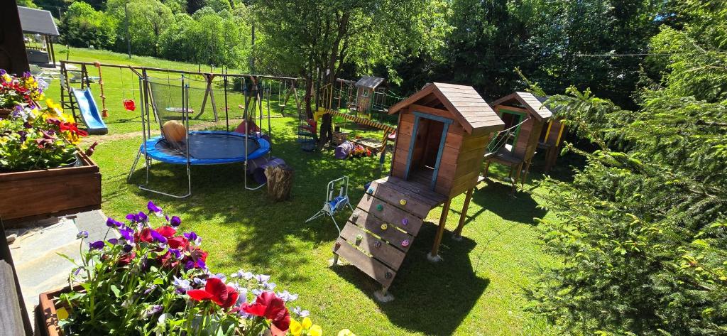um pequeno jardim com um conjunto de jogos e um parque infantil em JASTRZĄB em Ropienka
