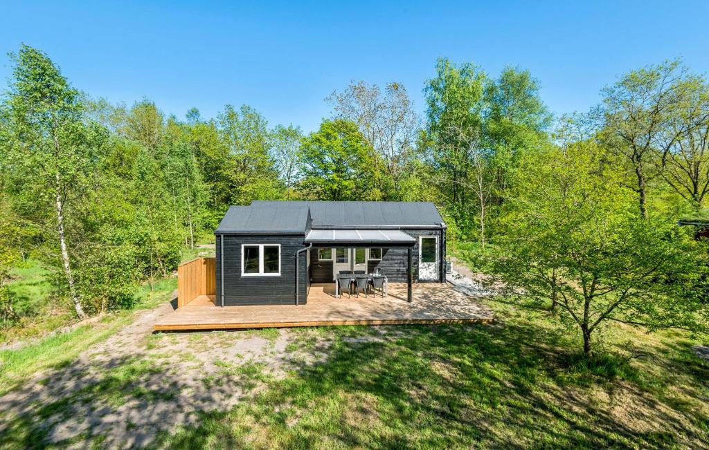 Ein schwarzes winziges Haus im Wald. in der Unterkunft Awesome Home In Give With Wifi in Give