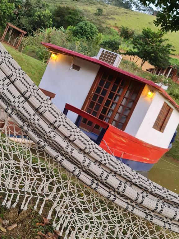 a model of a house with a boat in the water at Chalé Barco Recanto Buscapé SFX in São Francisco Xavier